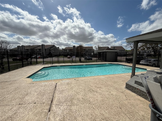 pool featuring a patio area, an outbuilding, a shed, and fence