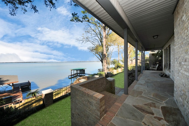 view of patio featuring a water view and fence