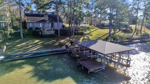 view of dock with boat lift, a yard, and a water view