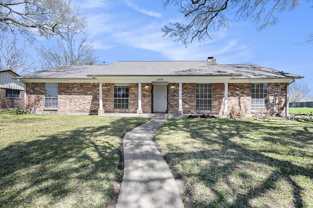 ranch-style home featuring a front lawn, a porch, brick siding, and a chimney