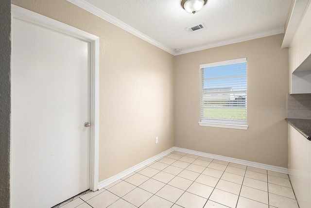 spare room with visible vents, crown molding, baseboards, light tile patterned floors, and a textured ceiling