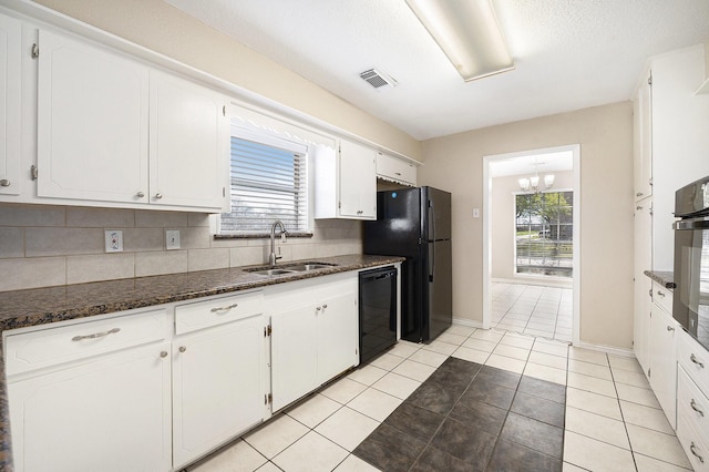 kitchen featuring visible vents, a sink, decorative backsplash, black appliances, and white cabinets