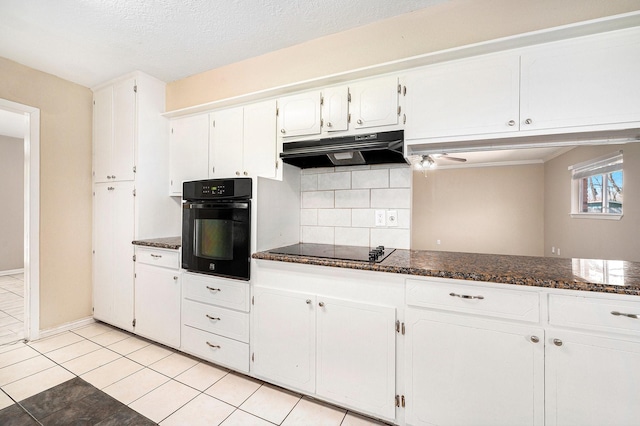 kitchen featuring black appliances, under cabinet range hood, dark stone countertops, backsplash, and white cabinets