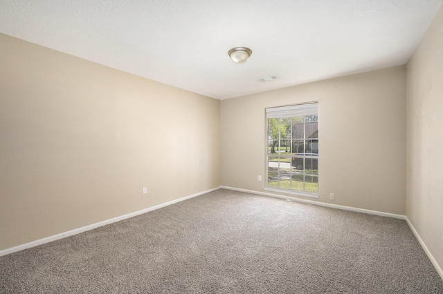 carpeted empty room featuring visible vents, baseboards, and a textured ceiling