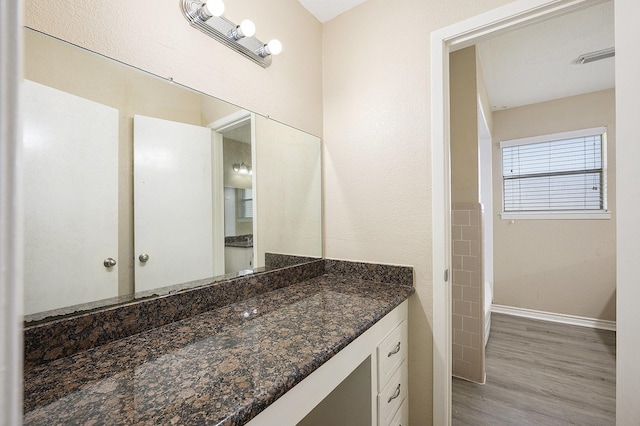 bathroom with vanity, baseboards, and wood finished floors