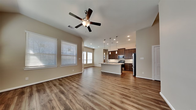 unfurnished living room featuring wood finished floors, baseboards, visible vents, recessed lighting, and ceiling fan