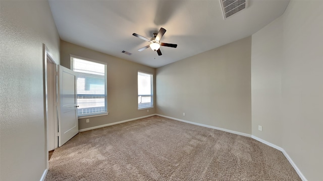 empty room with carpet, visible vents, and baseboards