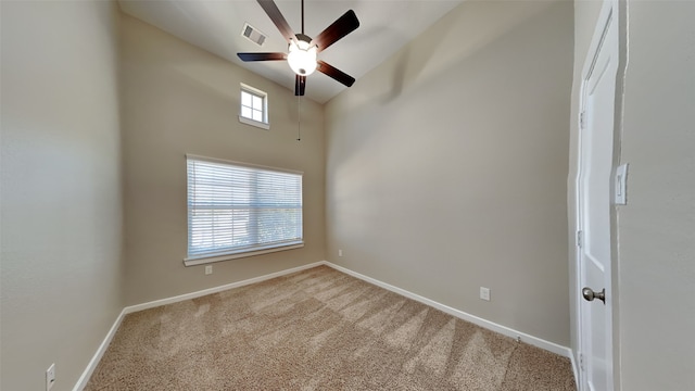 empty room with visible vents, carpet flooring, a ceiling fan, and baseboards