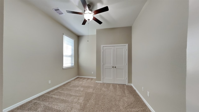 unfurnished room featuring visible vents, baseboards, light colored carpet, and ceiling fan