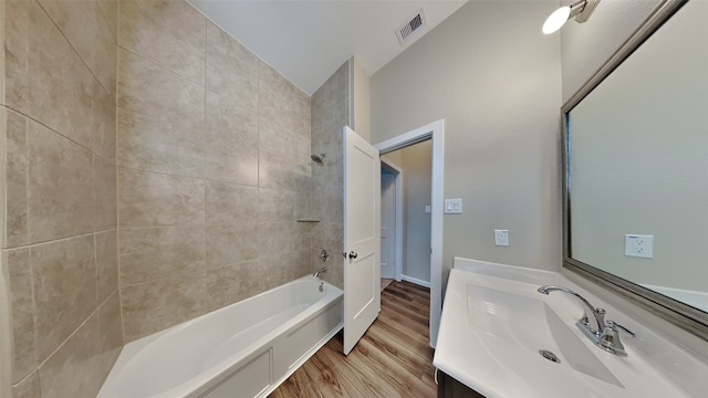 full bathroom with visible vents, bathing tub / shower combination, wood finished floors, and vanity