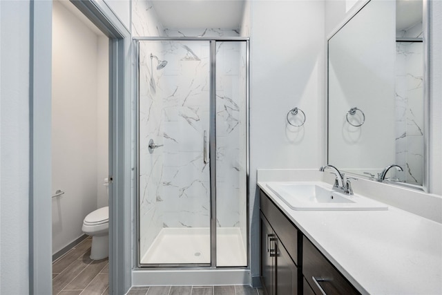 bathroom with a marble finish shower, toilet, vanity, and wood tiled floor