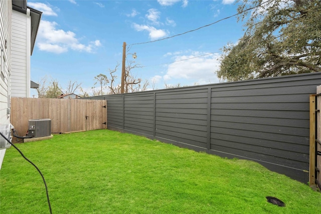 view of yard featuring central AC unit and a fenced backyard