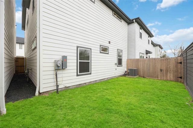 back of house featuring a yard, central air condition unit, and a fenced backyard