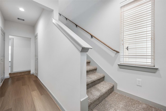 stairs with recessed lighting, visible vents, baseboards, and wood finished floors