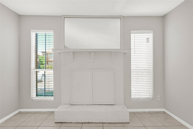 interior details with a brick fireplace, baseboards, and a textured ceiling