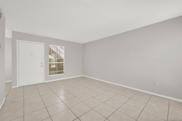 spare room featuring baseboards and a textured ceiling