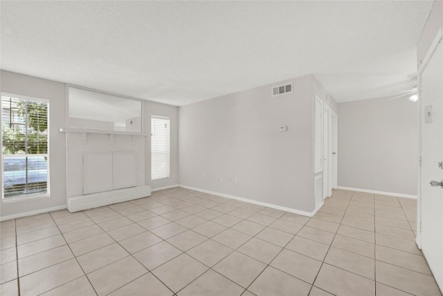 unfurnished room featuring ceiling fan, baseboards, visible vents, and a textured ceiling