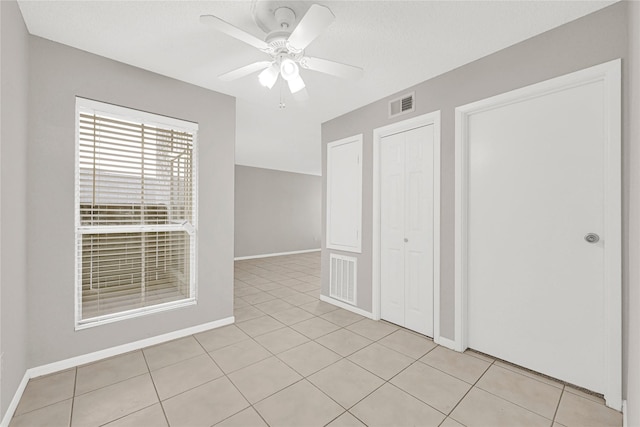 unfurnished bedroom featuring a closet, visible vents, baseboards, and light tile patterned floors