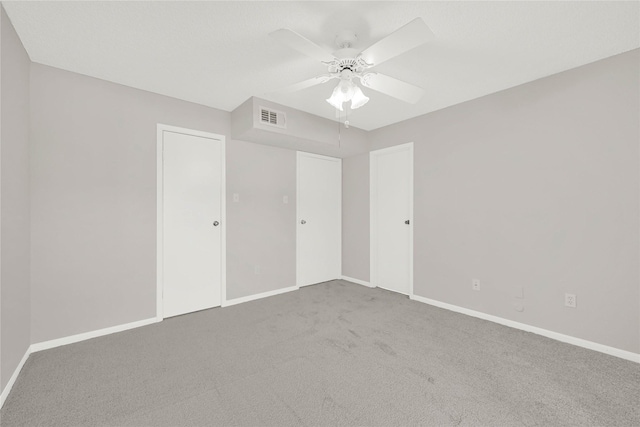 unfurnished bedroom featuring visible vents, ceiling fan, baseboards, and carpet