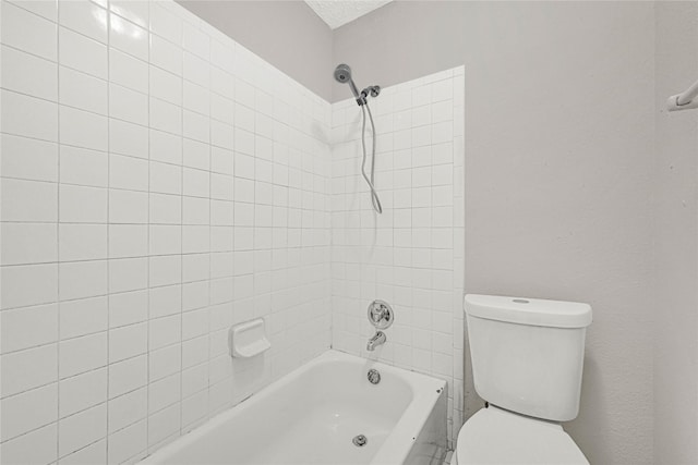 bathroom featuring a textured ceiling, toilet, and bathtub / shower combination