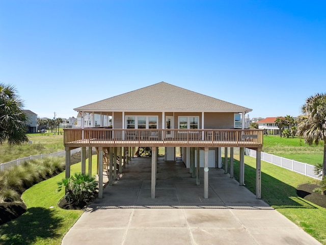 exterior space featuring a carport, a yard, concrete driveway, and roof with shingles