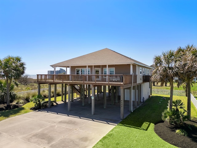 back of property featuring a carport, driveway, and a lawn