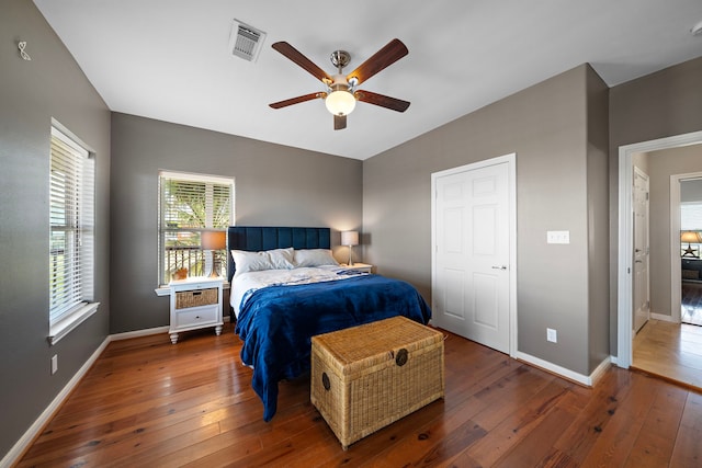 bedroom with visible vents, baseboards, and hardwood / wood-style floors