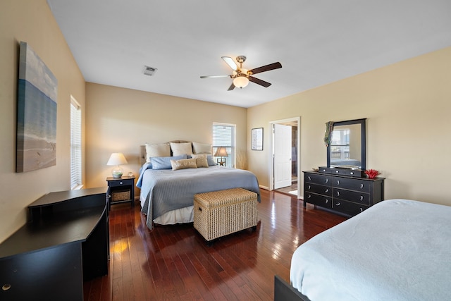 bedroom with dark wood-type flooring, a ceiling fan, and visible vents