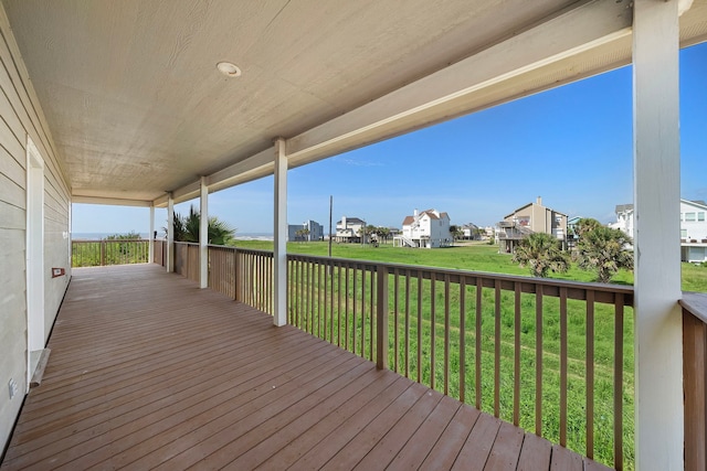 wooden terrace with a residential view and a lawn