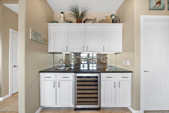 bar with wine cooler, indoor wet bar, baseboards, and a sink