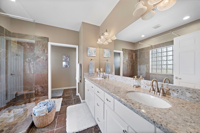 full bath featuring double vanity, visible vents, walk in shower, and a sink