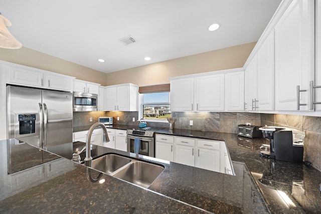 kitchen with a sink, visible vents, appliances with stainless steel finishes, and white cabinetry