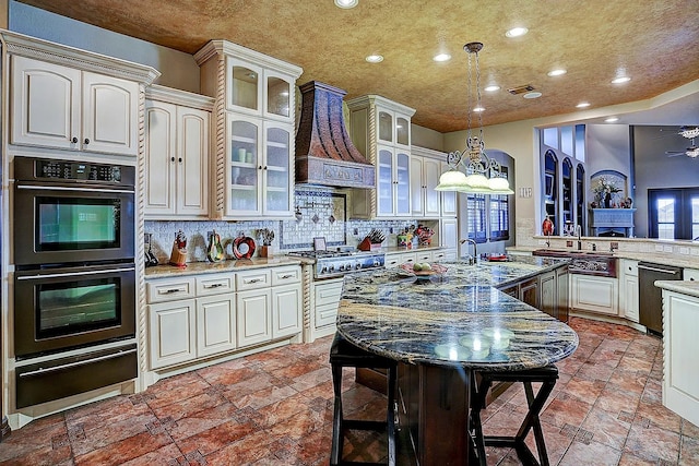 kitchen featuring premium range hood, double wall oven, stainless steel gas stovetop, dishwasher, and a warming drawer