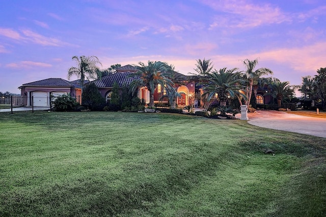 mediterranean / spanish home featuring a front lawn and fence