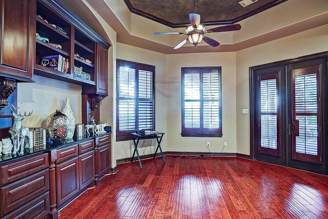 interior space featuring french doors, a raised ceiling, visible vents, and dark wood finished floors