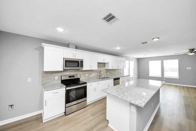 kitchen featuring visible vents, backsplash, appliances with stainless steel finishes, and white cabinetry