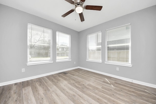 empty room featuring ceiling fan, baseboards, and wood finished floors