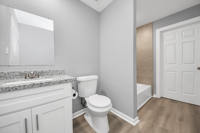 full bath featuring toilet, vanity, baseboards, and wood finished floors