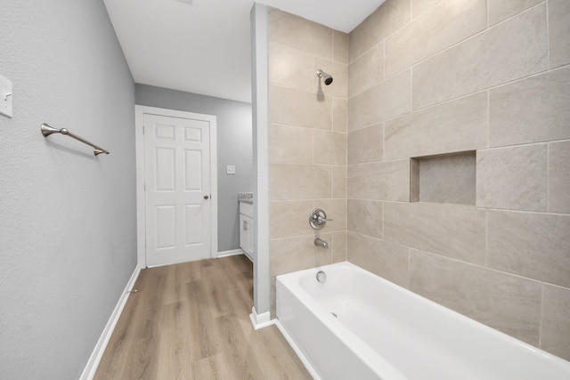 full bathroom with tub / shower combination, baseboards, and wood finished floors