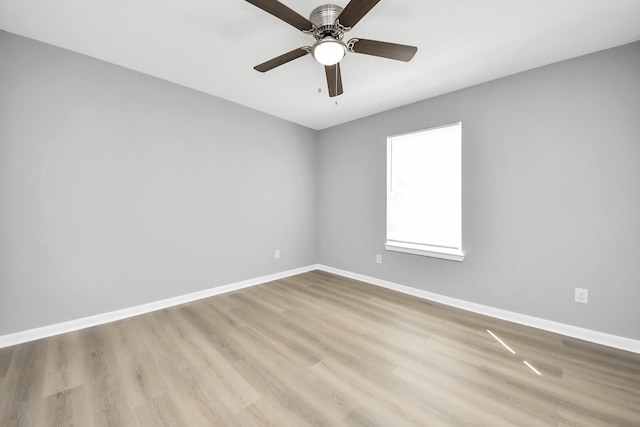 empty room with baseboards, wood finished floors, and a ceiling fan