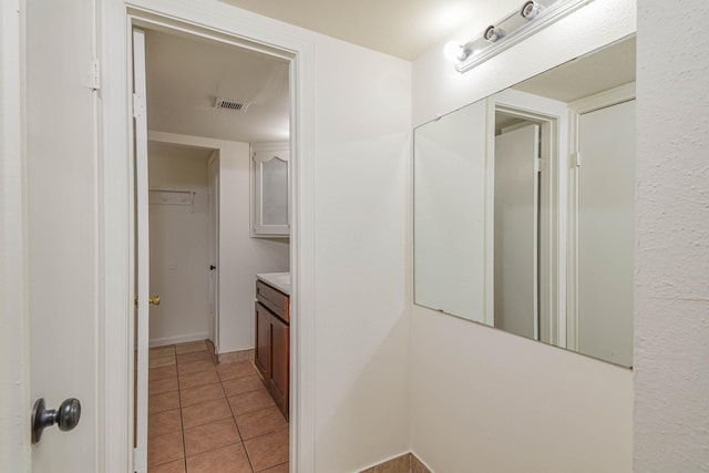 hall featuring visible vents and light tile patterned flooring