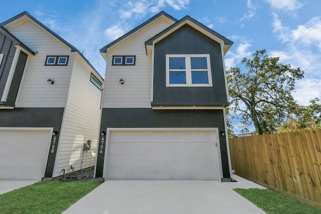 view of front of property featuring concrete driveway, a garage, fence, and board and batten siding