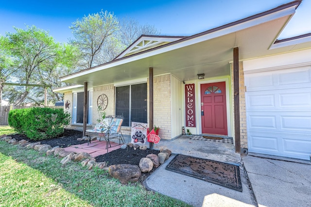 property entrance with a garage, brick siding, and covered porch