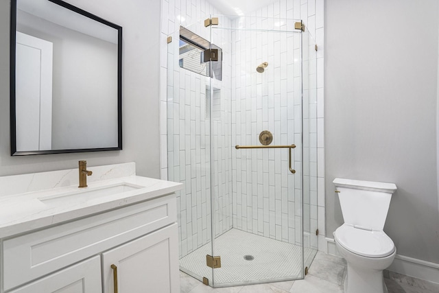 bathroom with a stall shower, toilet, vanity, and baseboards