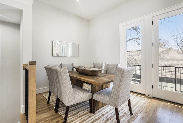 dining area with light wood-type flooring and baseboards