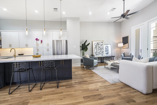 living room with recessed lighting, visible vents, light wood-style flooring, and a ceiling fan