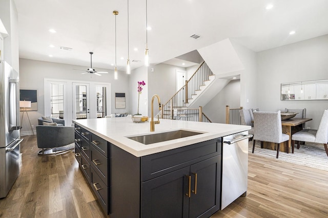 kitchen featuring a sink, light wood-style floors, appliances with stainless steel finishes, and open floor plan