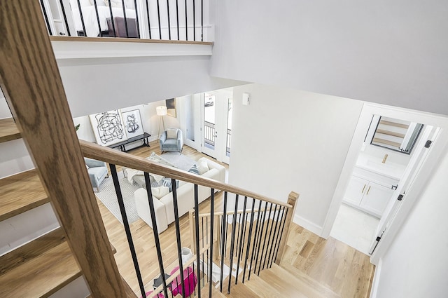 stairs with wood finished floors and baseboards