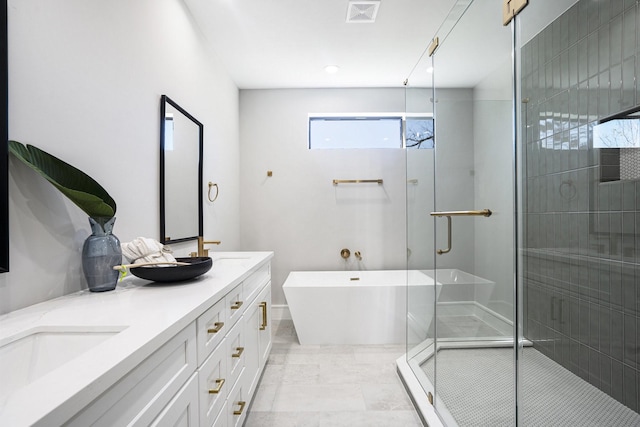 bathroom with visible vents, double vanity, a stall shower, a freestanding bath, and a sink