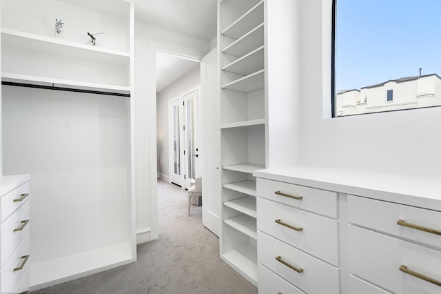 walk in closet featuring light colored carpet